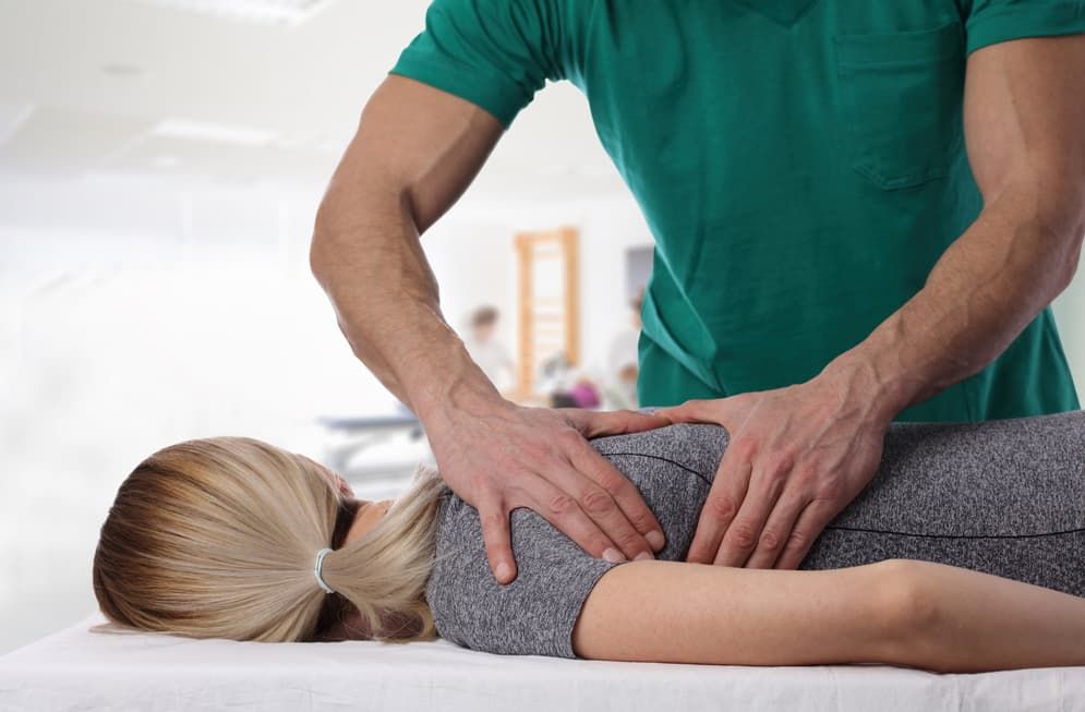 Man Giving A Shoulder Massage To A Woman Lying On A Massage Table — Integrate Health In Marian, QLD