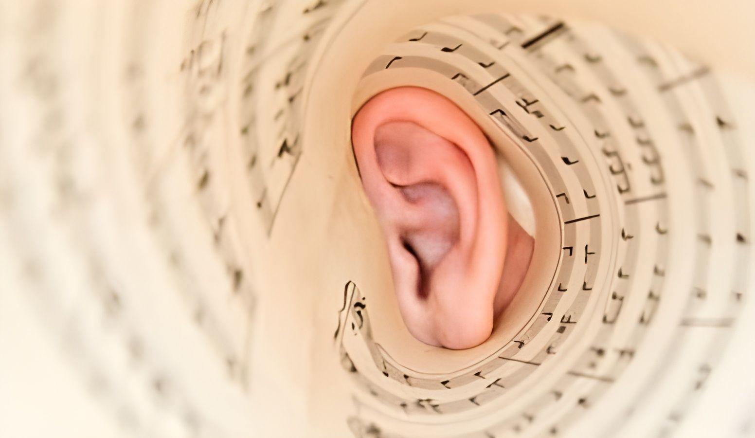 Close-up of a human ear framed by a beige spiral pattern