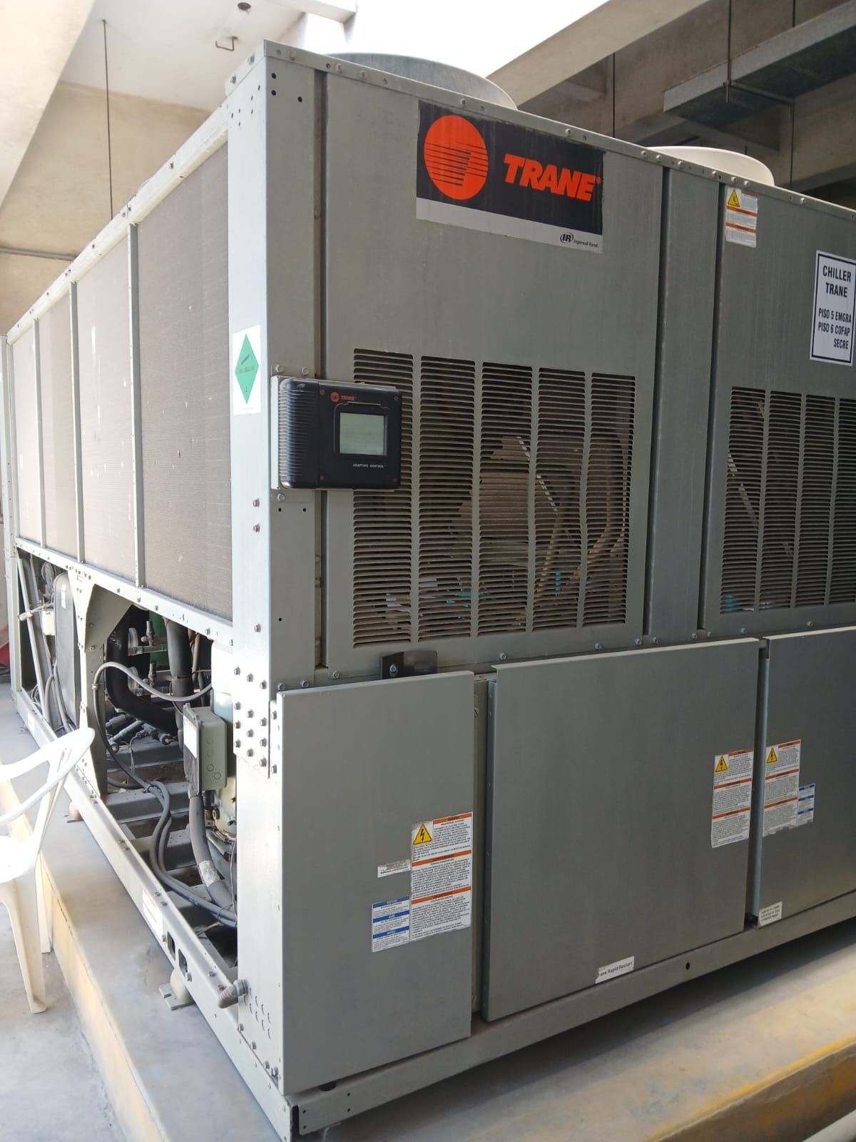Gran unidad de climatización Trane gris para techo con rejillas de ventilación y paneles de acceso en un tejado.