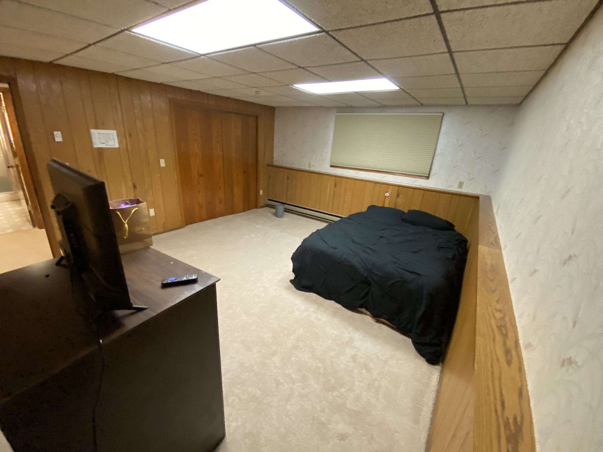 A bedroom with a bed and a television in it
