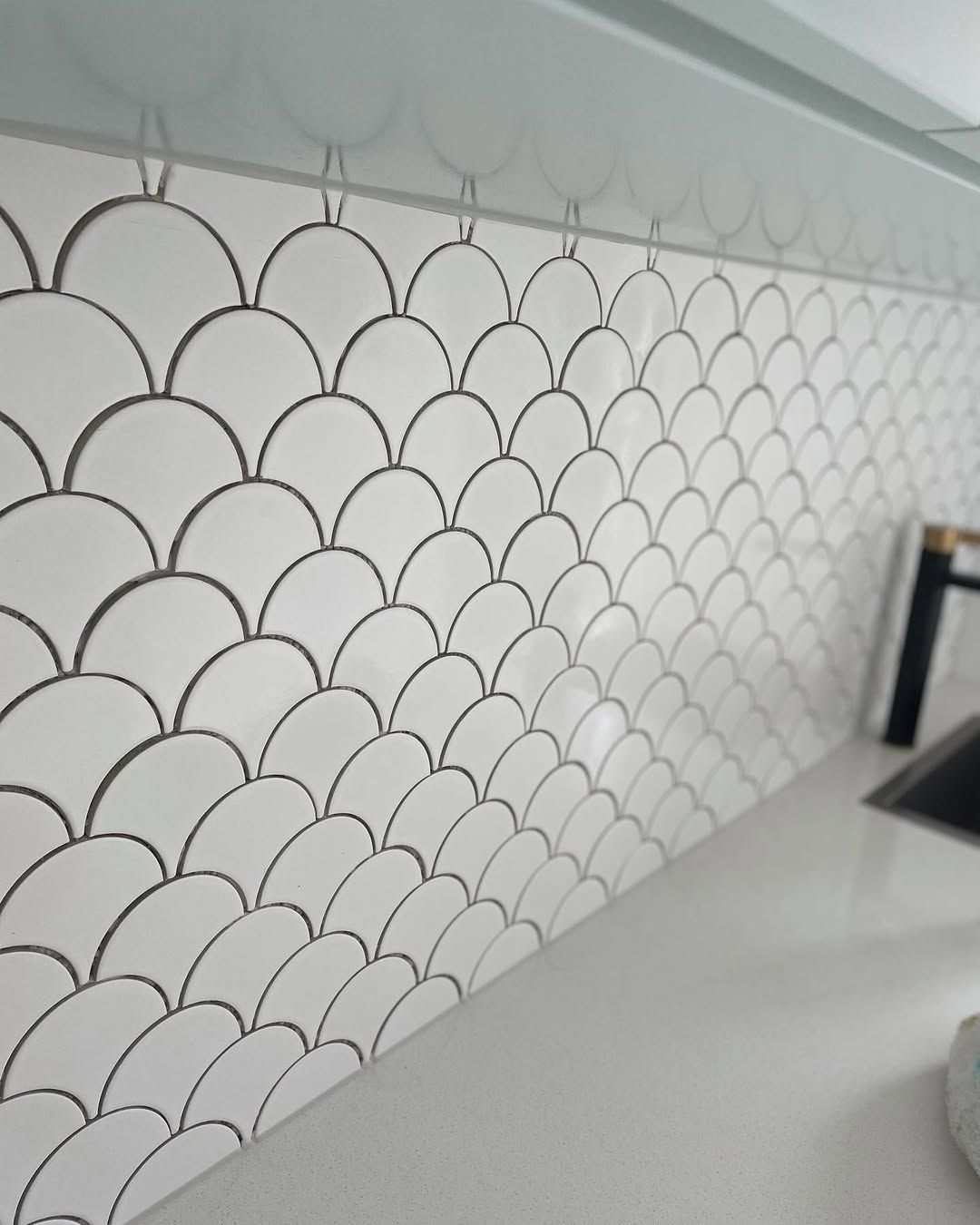 White Scalloped Tile Backsplash With Gray Grout Against a Countertop Angled View — Seeto Tiling in Fingal Bay, NSW