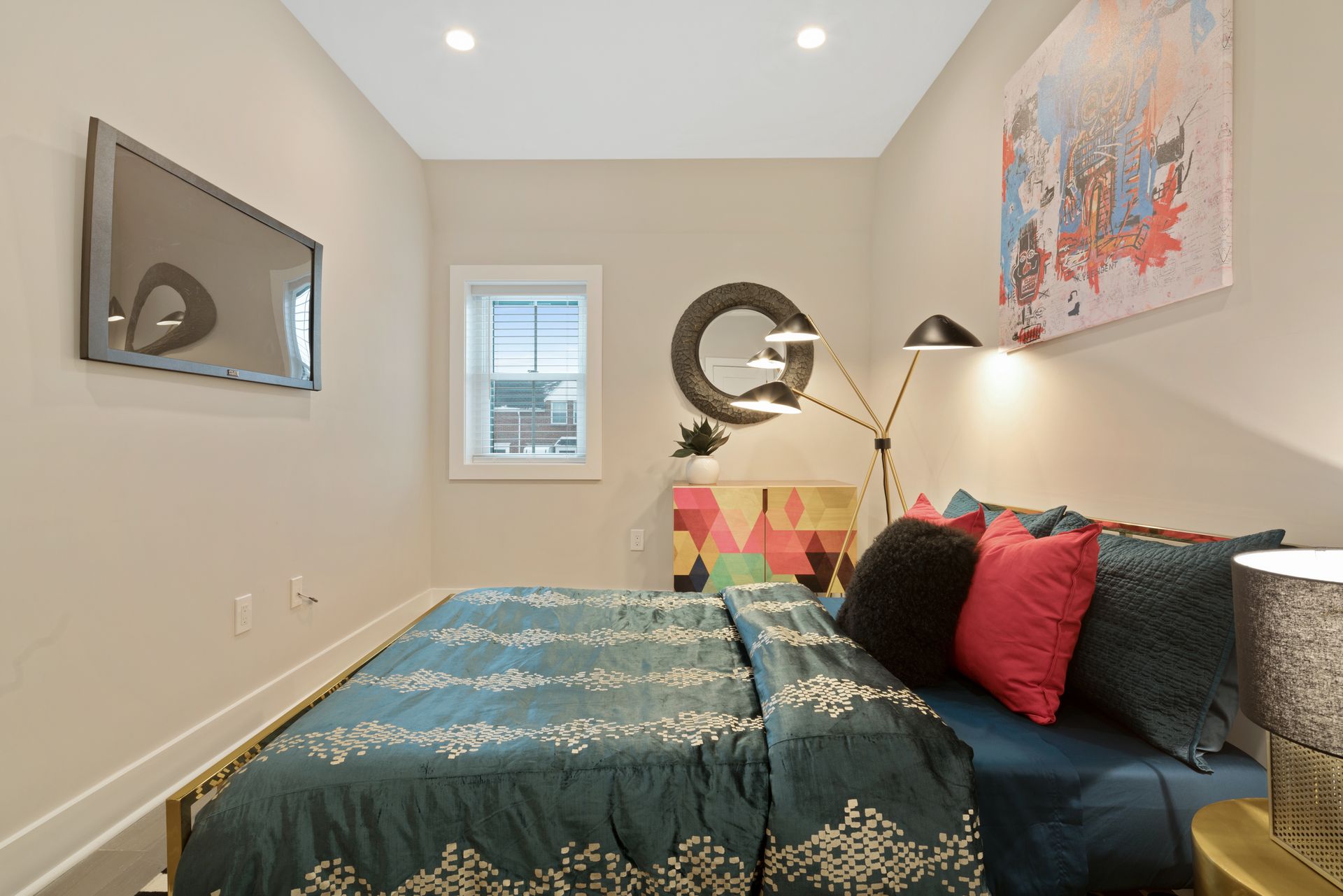 A bedroom with a bed and a television on the wall.