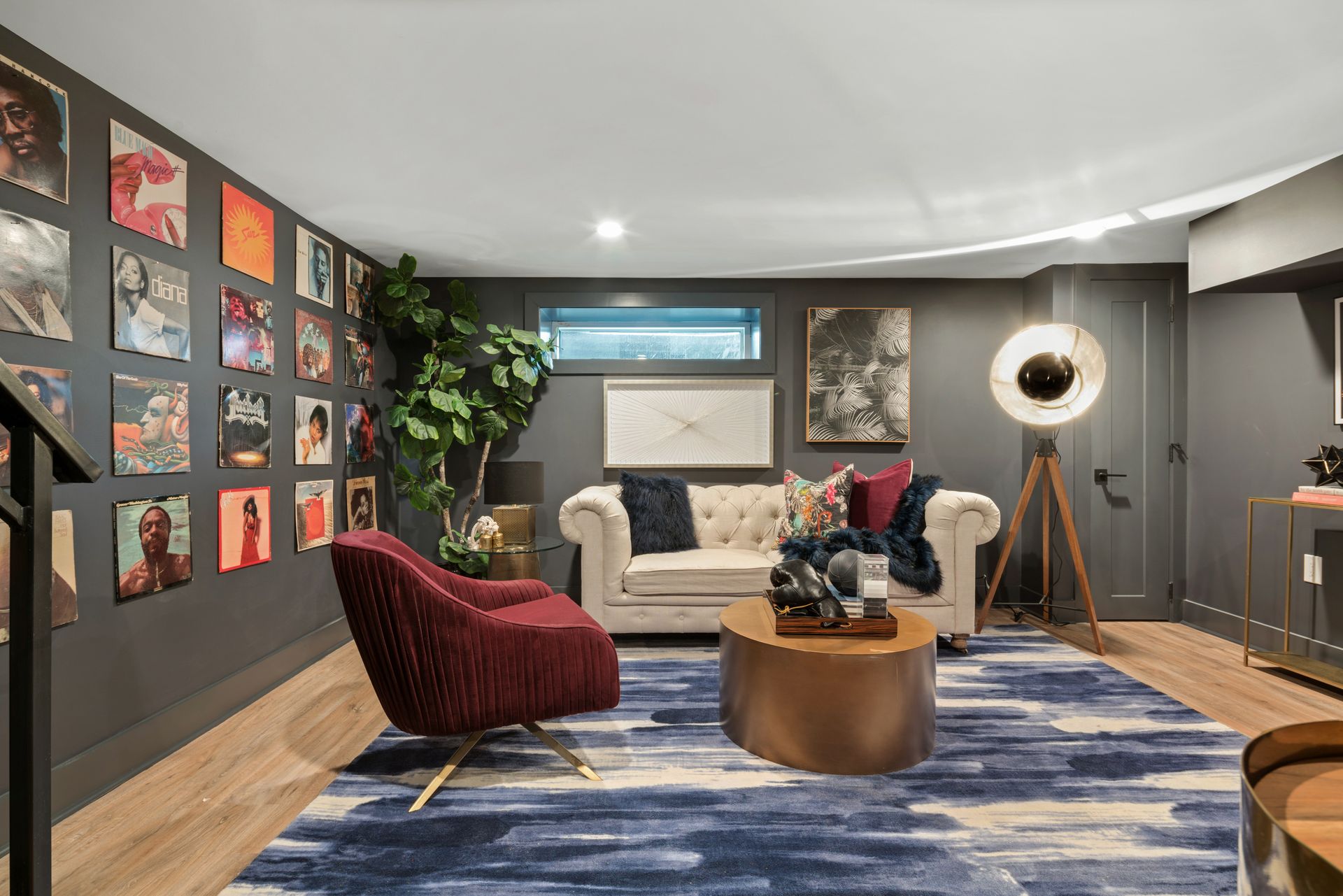 A living room with a couch , chair , coffee table and pictures on the wall.
