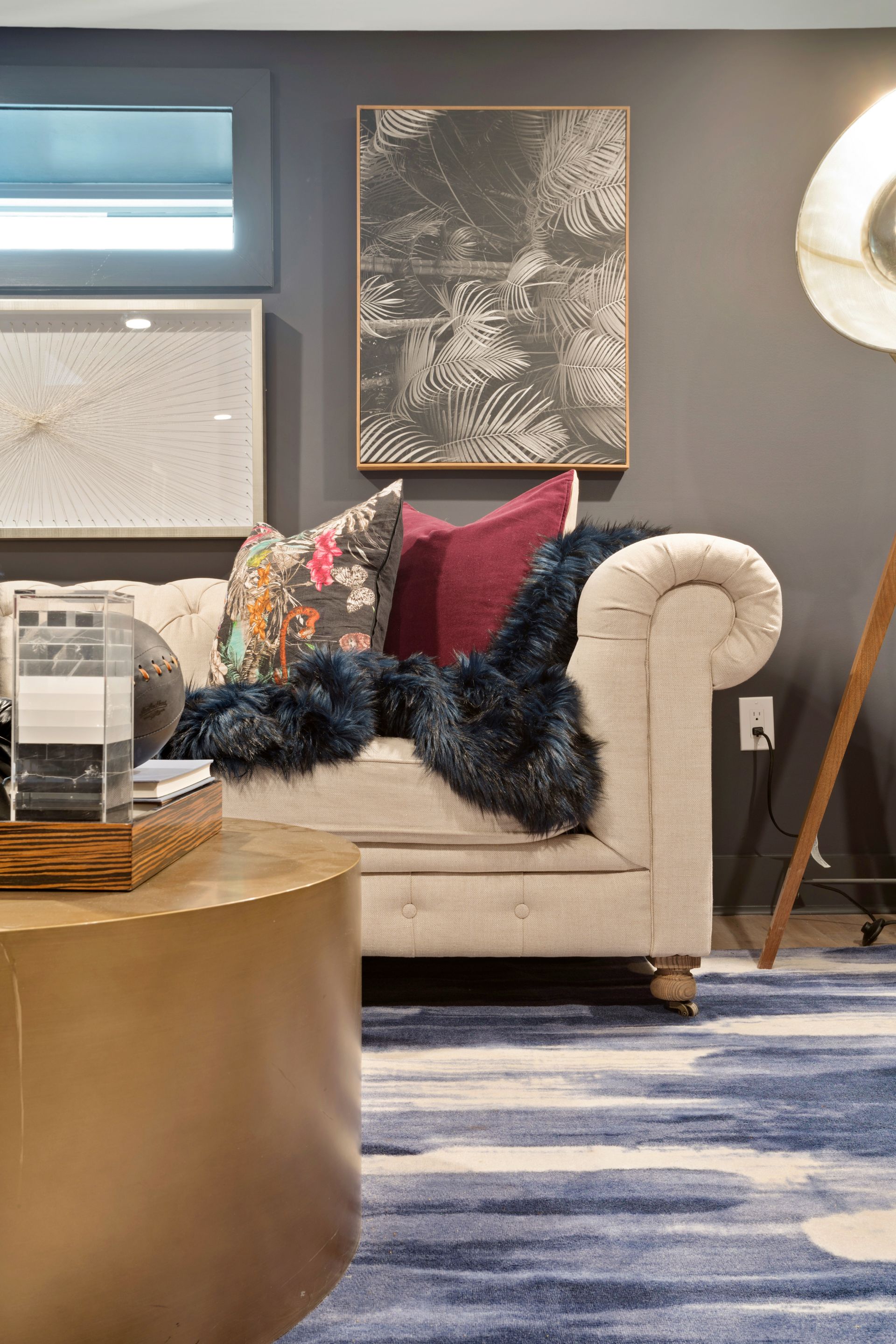 A living room with a couch , table , lamp and rug.