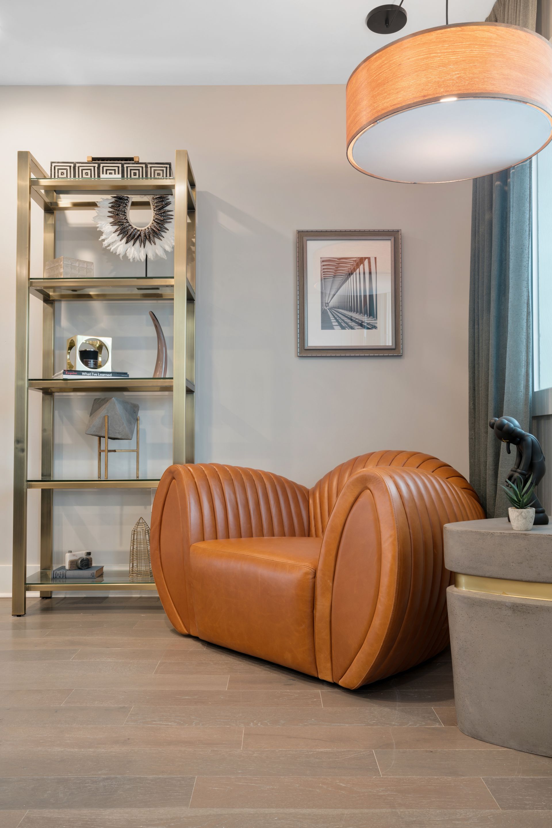 A living room with a brown leather chair and a shelf.