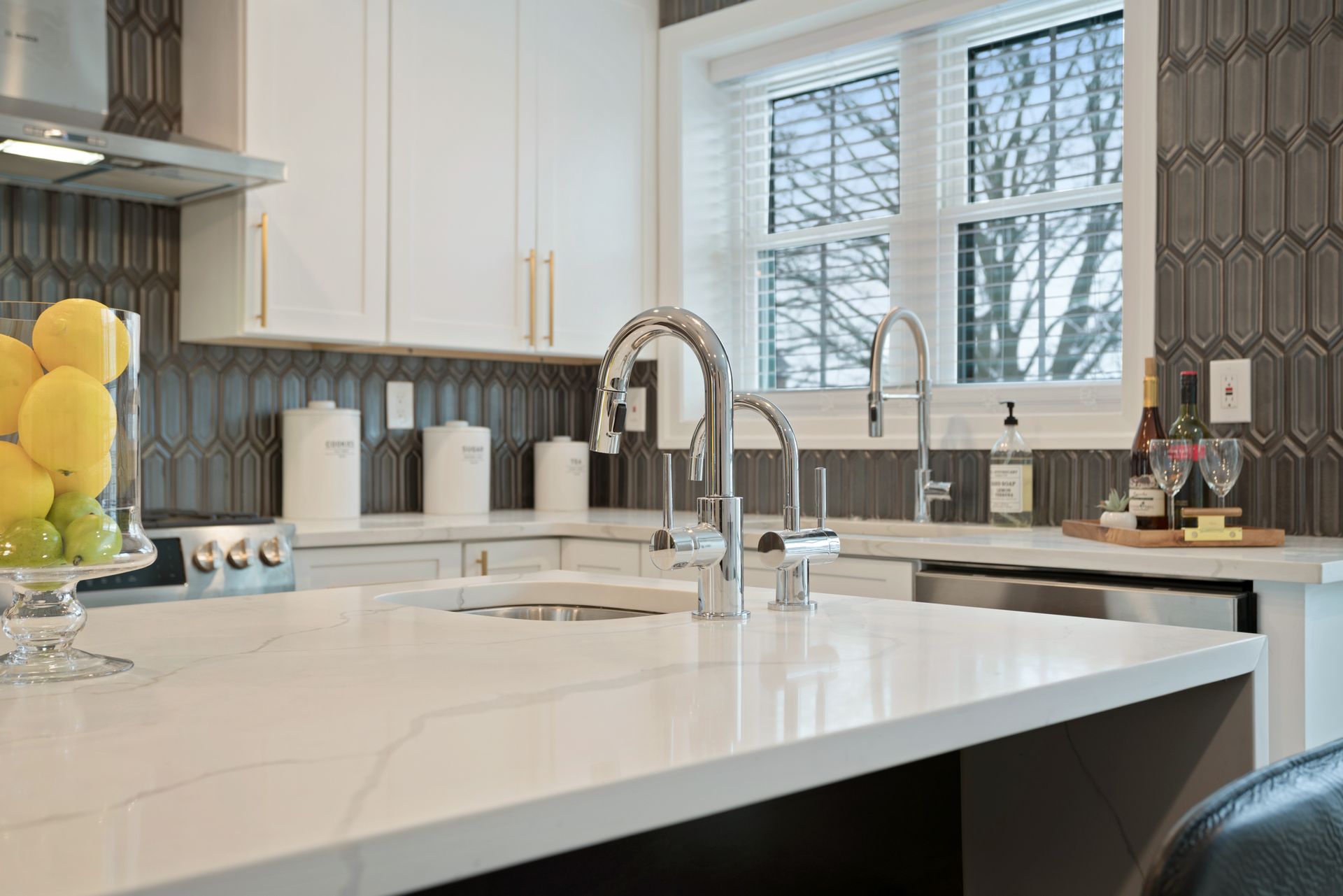 A kitchen with white cabinets , a sink , and a window.