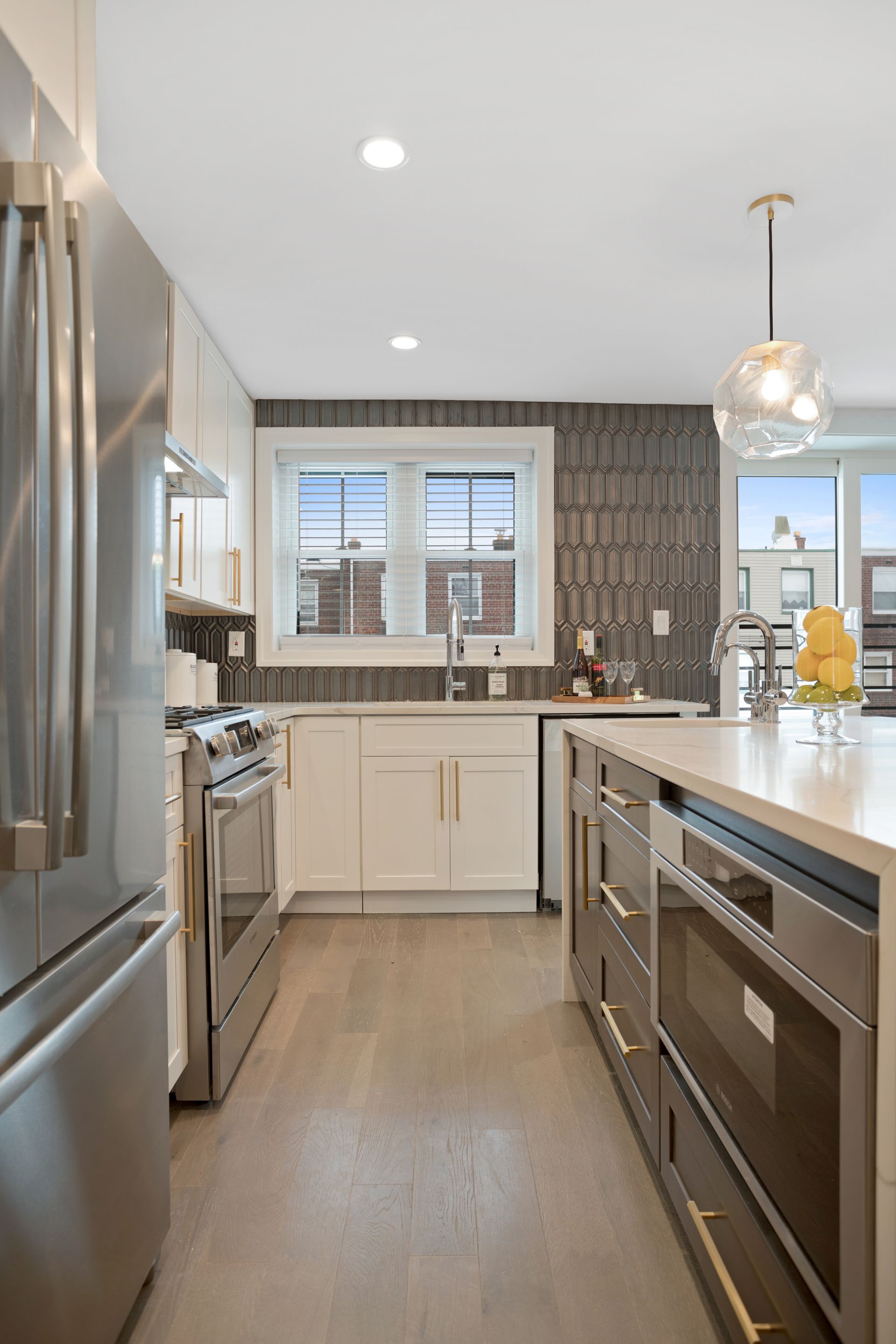 A kitchen with stainless steel appliances and white cabinets.