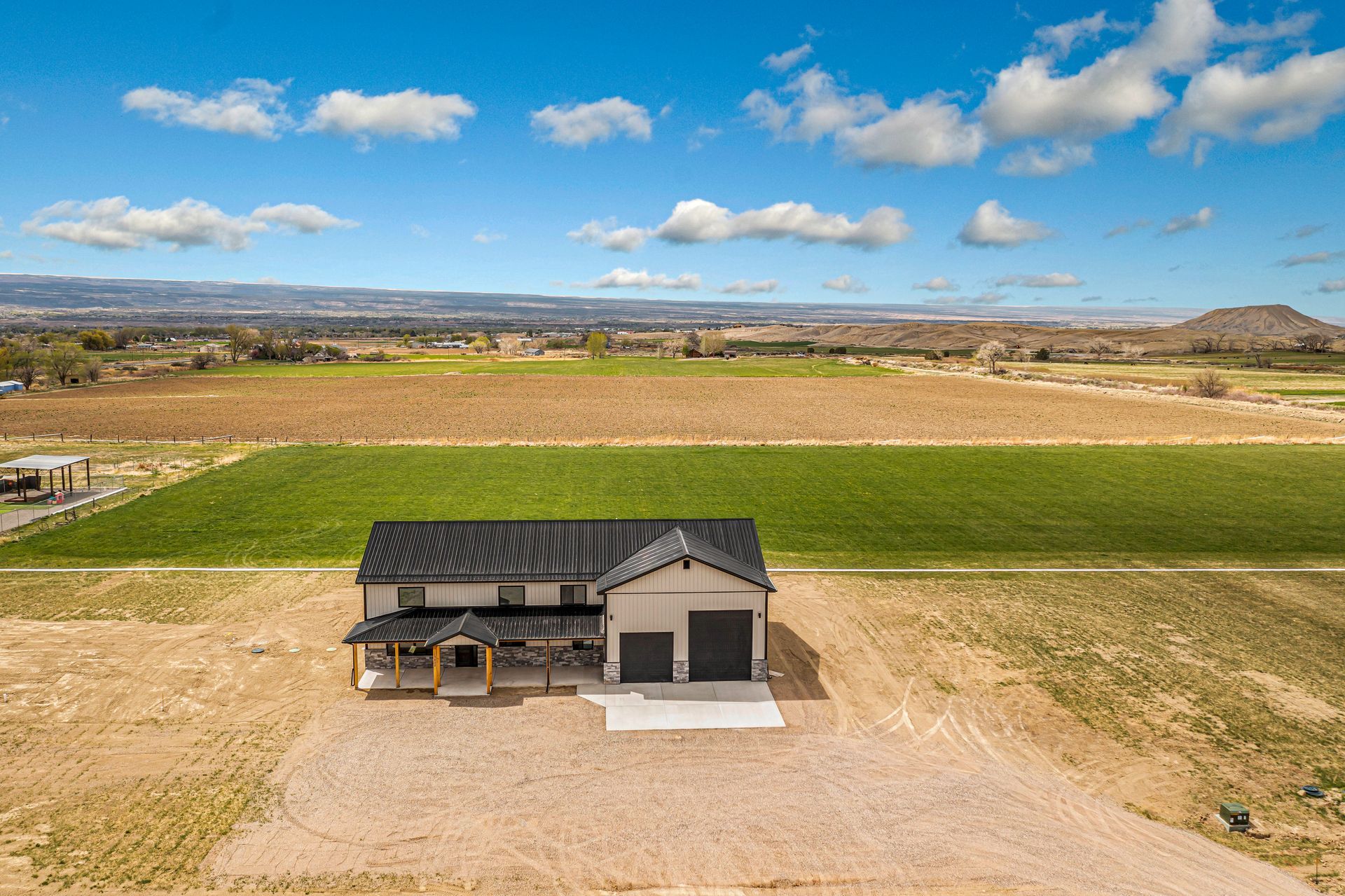 An aerial view of a house in the middle of a field.