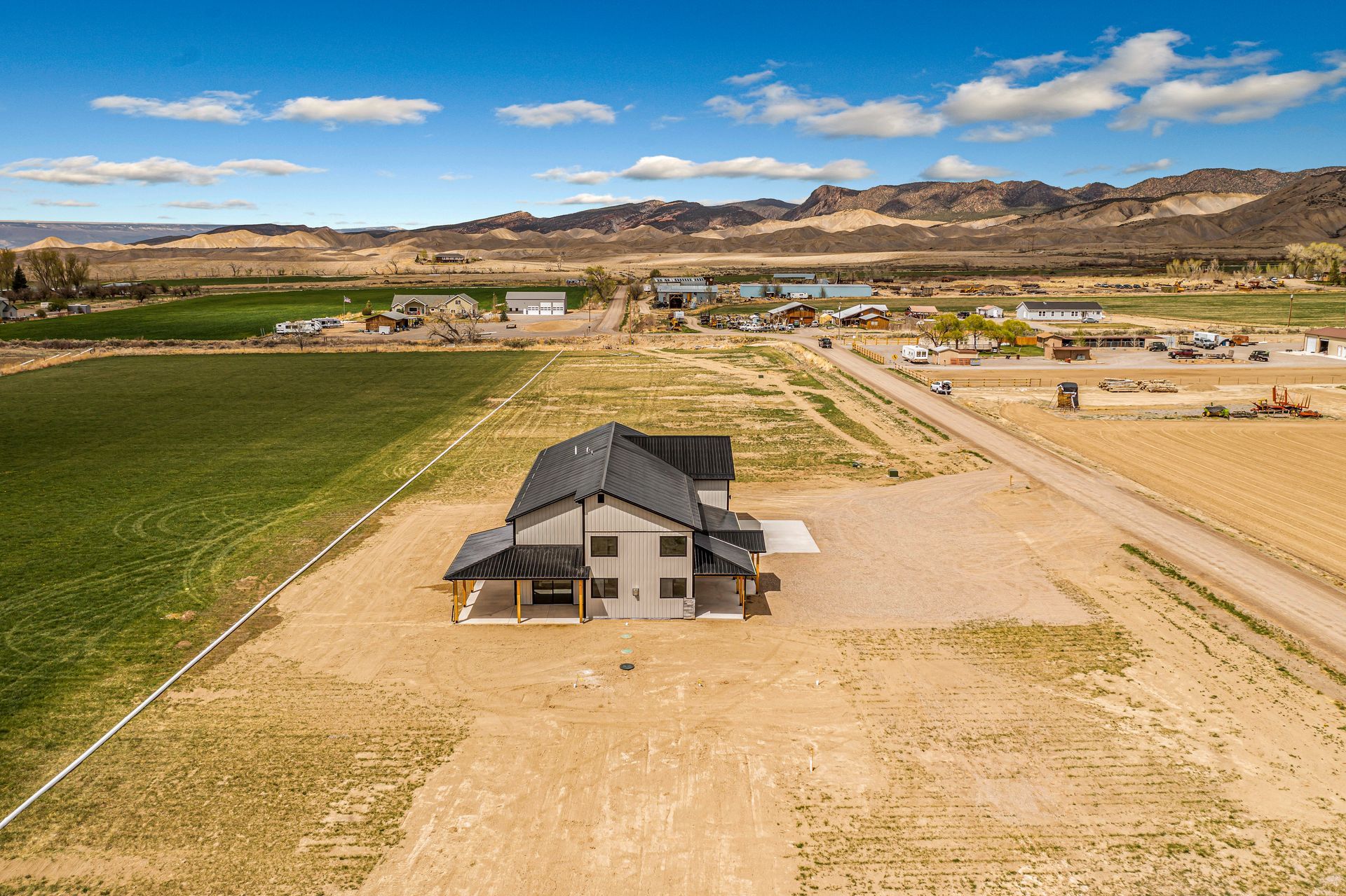 An aerial view of a house in the middle of a field.