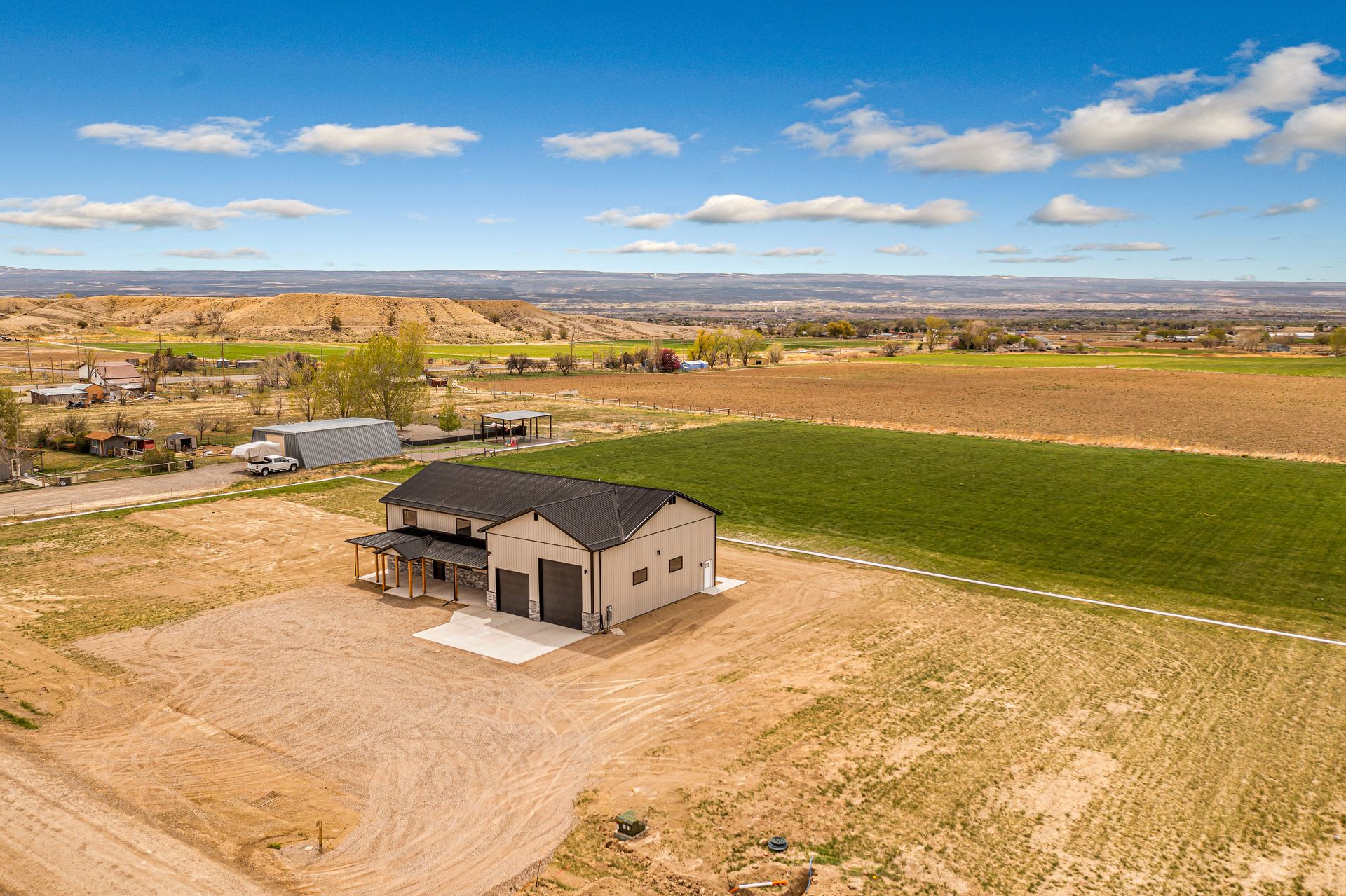 An aerial view of a house in the middle of a field.