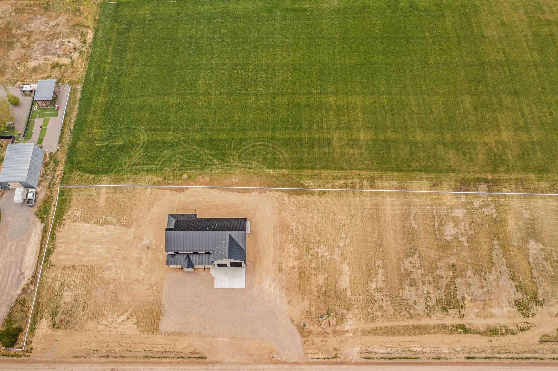 An aerial view of a house in the middle of a field.
