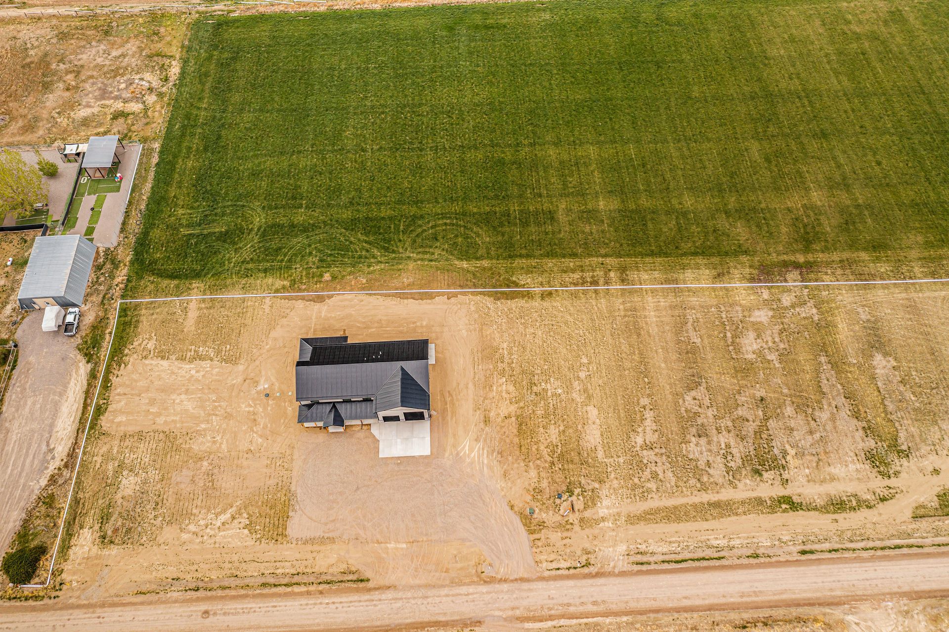 An aerial view of a house in the middle of a field.