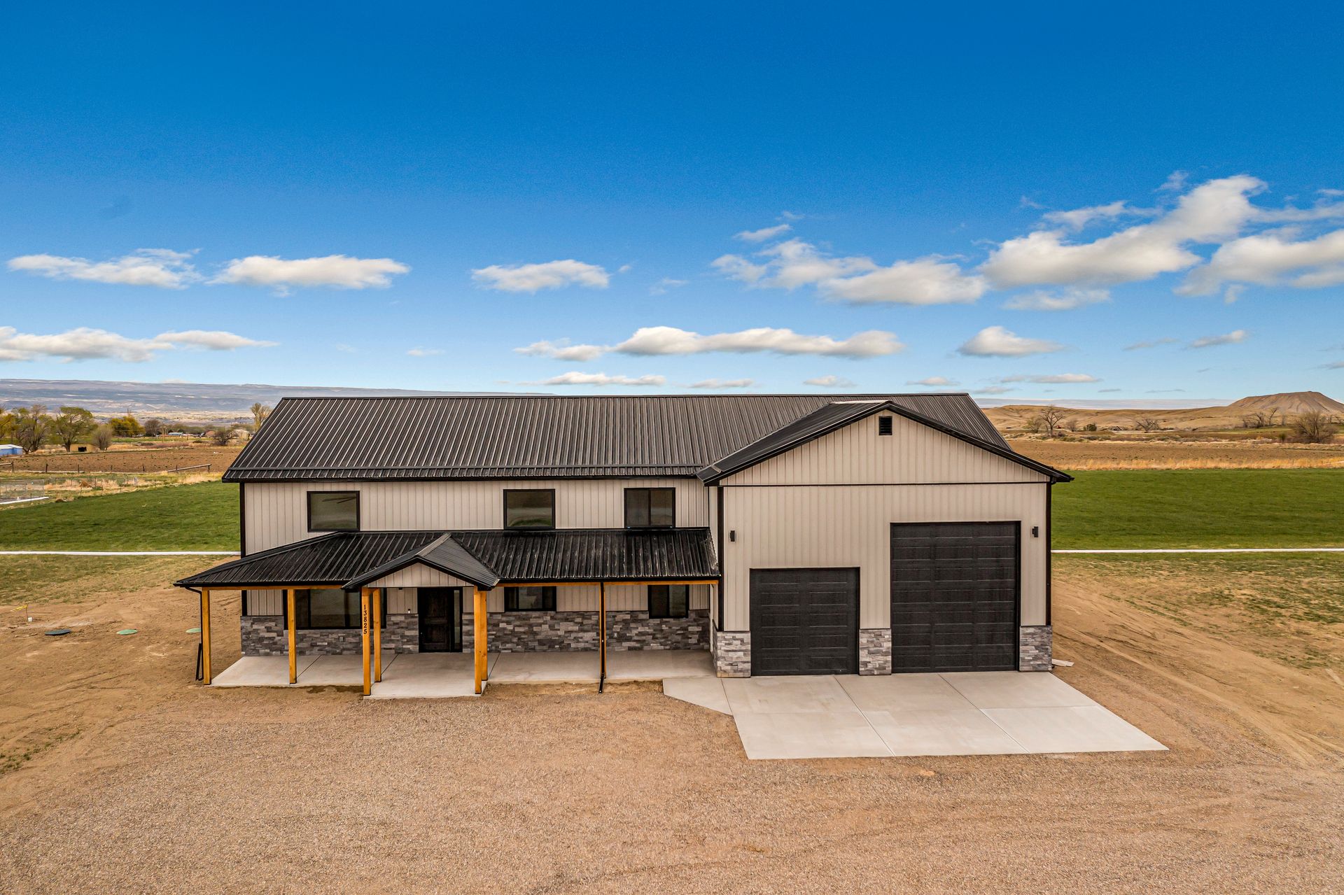 An aerial view of a large house in the middle of a field.