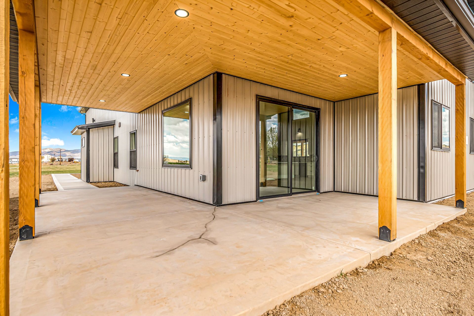 The back of a house with a covered patio and a wooden ceiling.