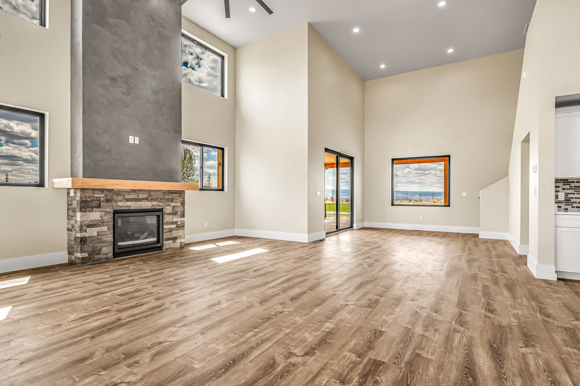 An empty living room with hardwood floors and a fireplace.