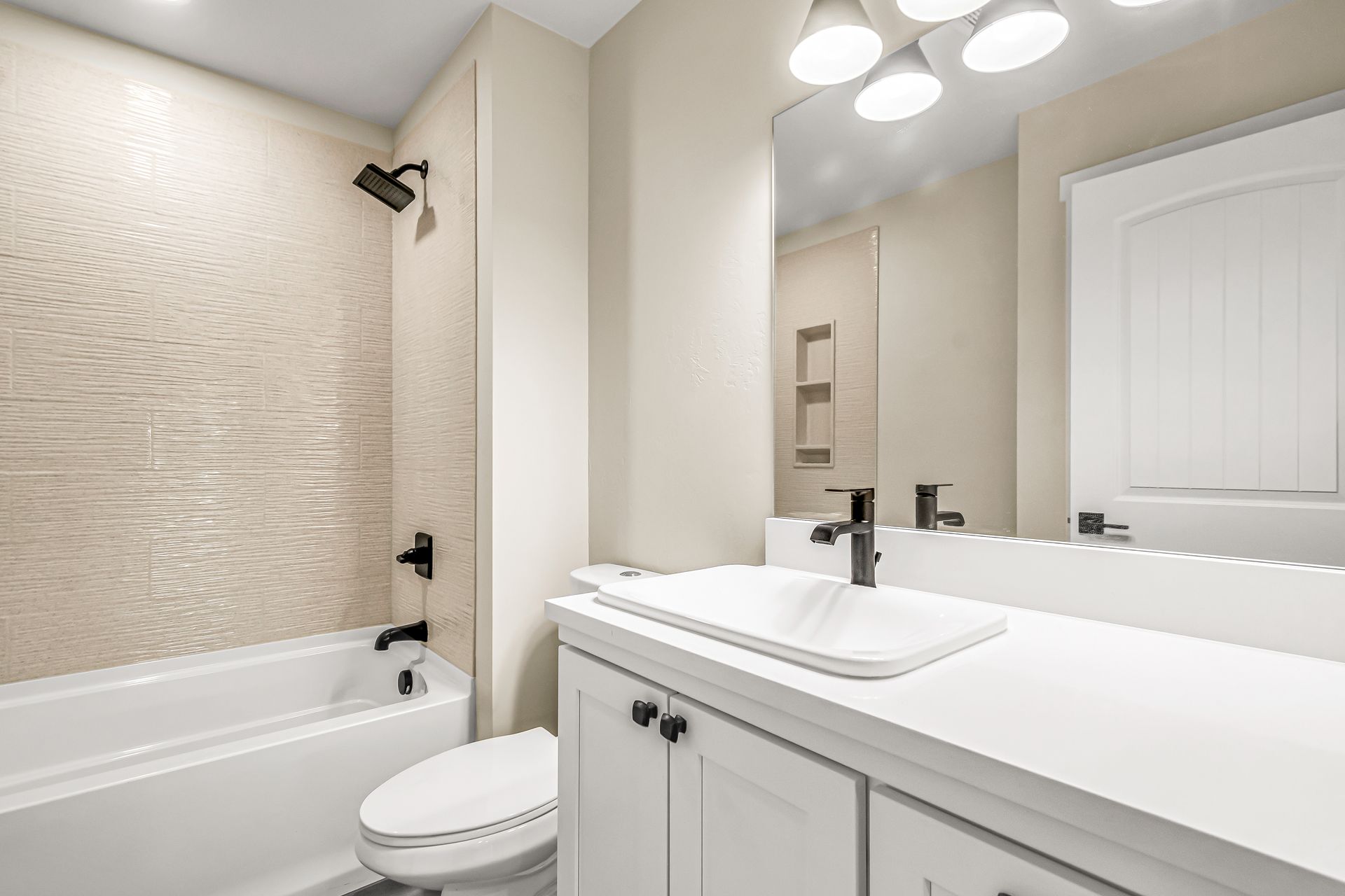 A bathroom with a sink , toilet , tub and mirror.
