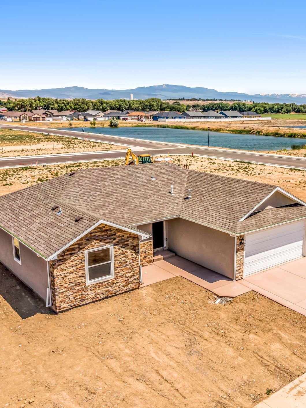An aerial view of a house with a river in the background.
