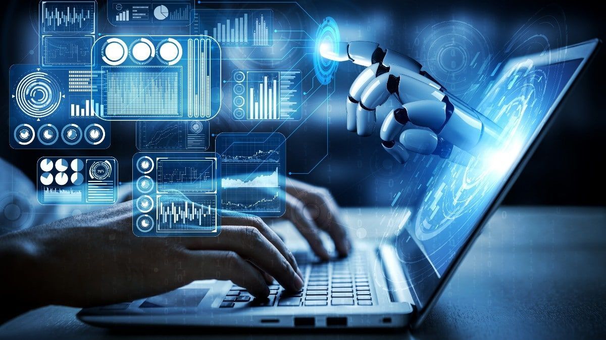 Uma pessoa está digitando em um laptop com um braço robótico ao fundo.