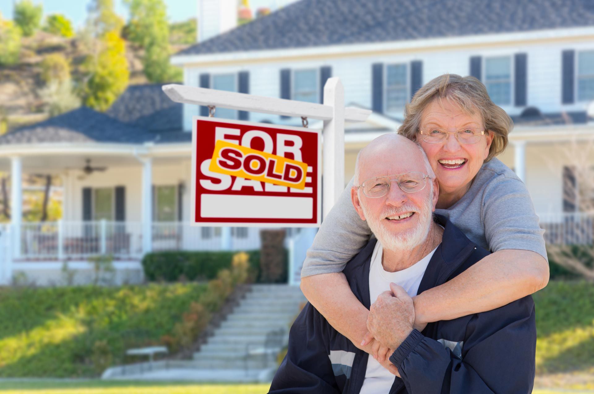 Couple smiling in front of a house with a 