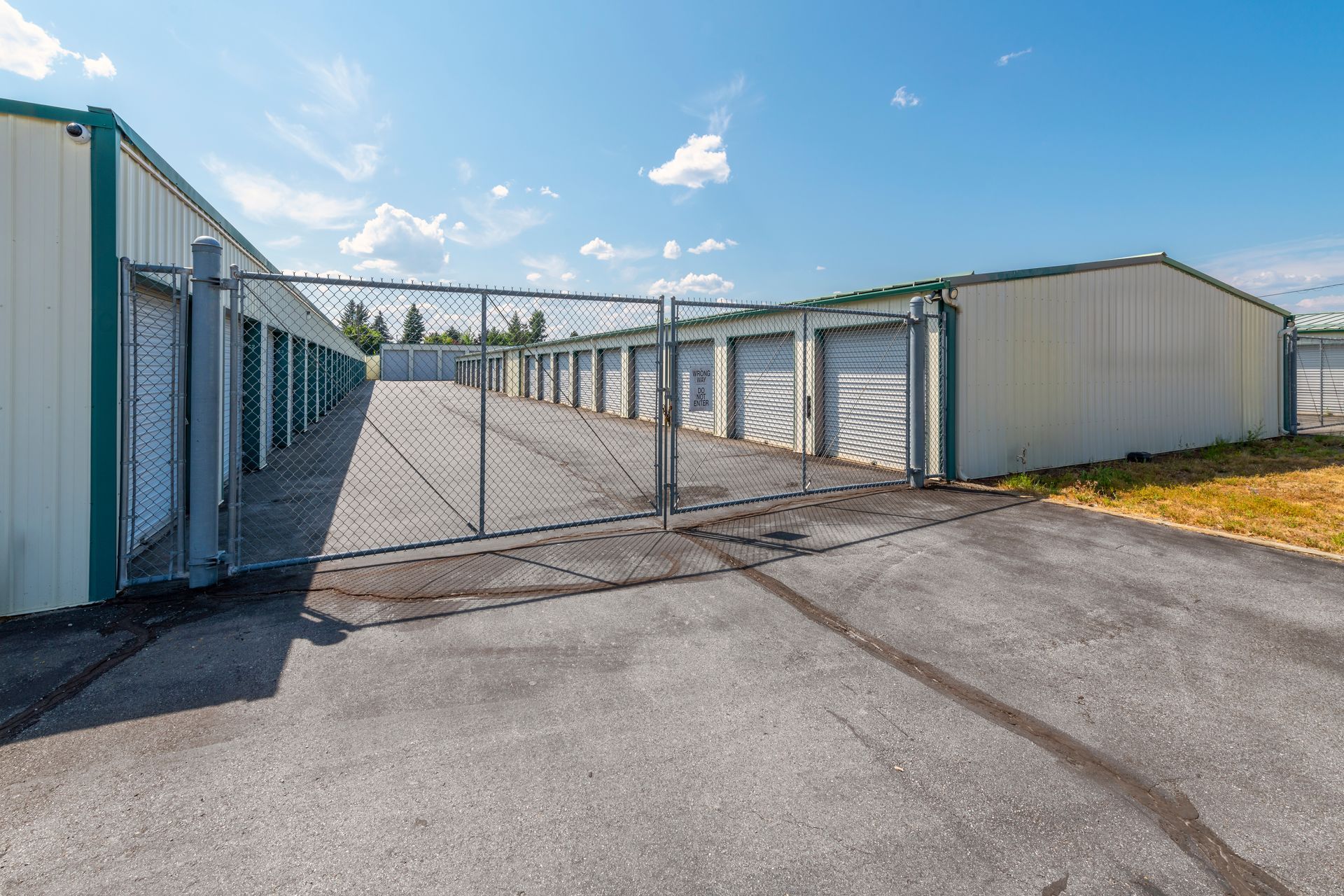 A row of storage units behind a chain link fence.