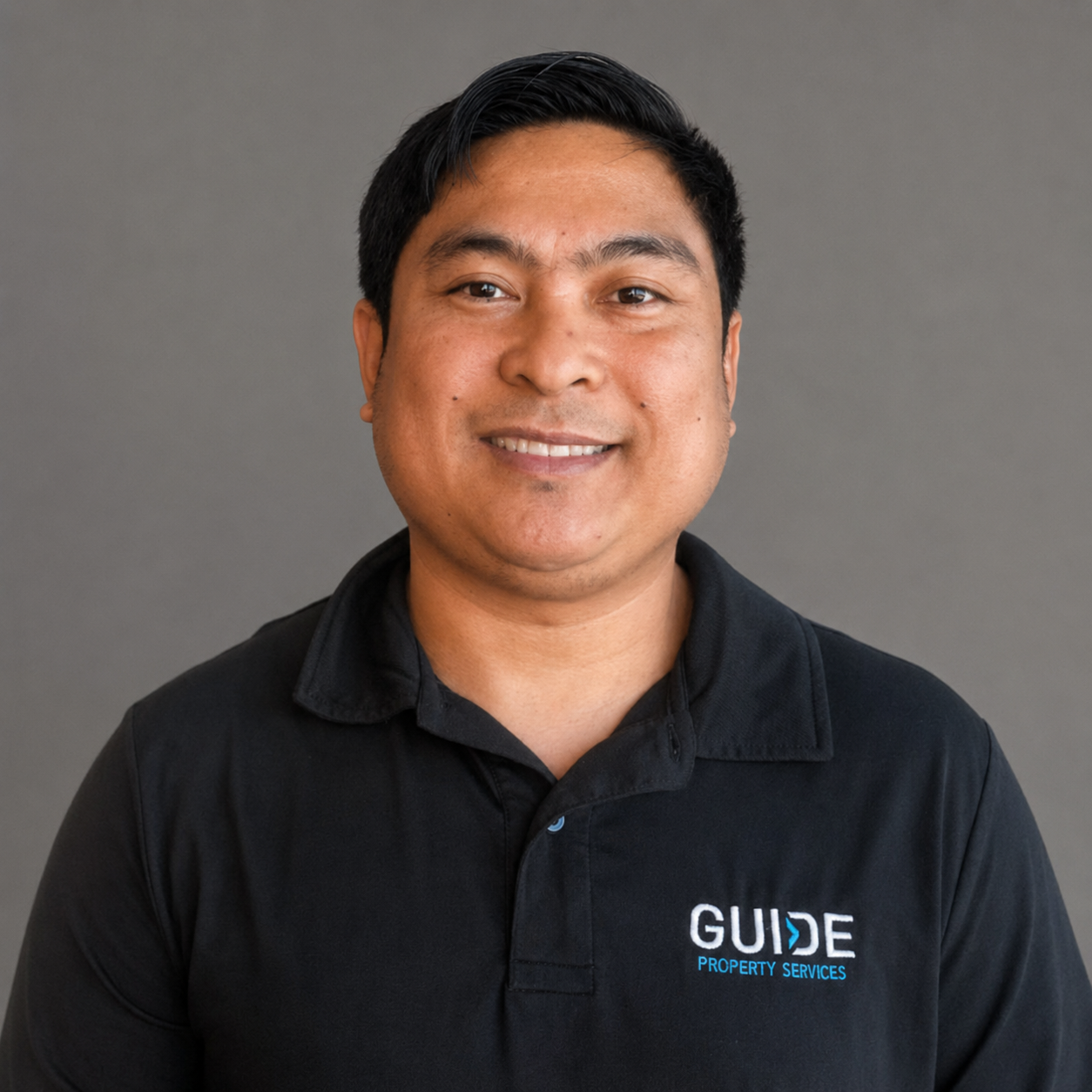 Smiling person in a black GUJIE polo shirt against a plain gray background