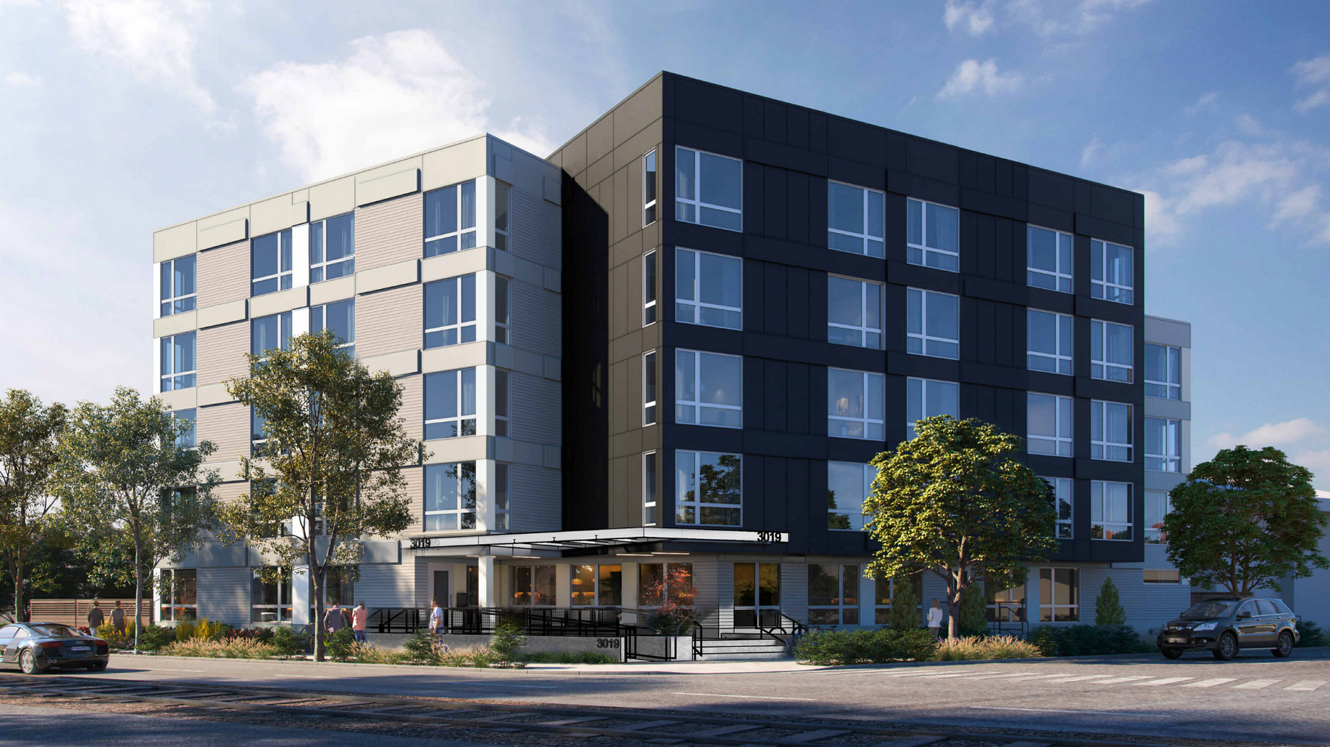 Modern multi-story office building with glass windows and a dark exterior, viewed from the street.