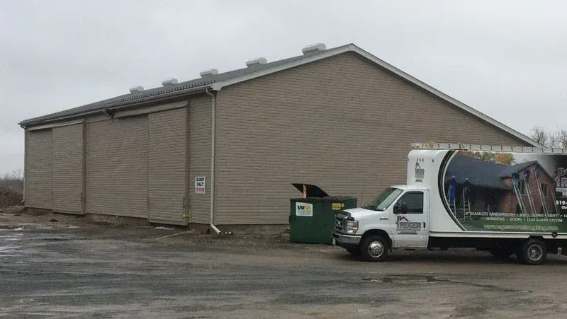 A white truck is parked in front of a building.