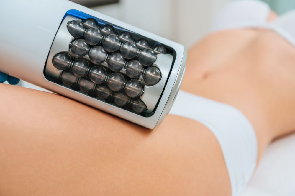 A woman is getting a massage on her leg with a machine.