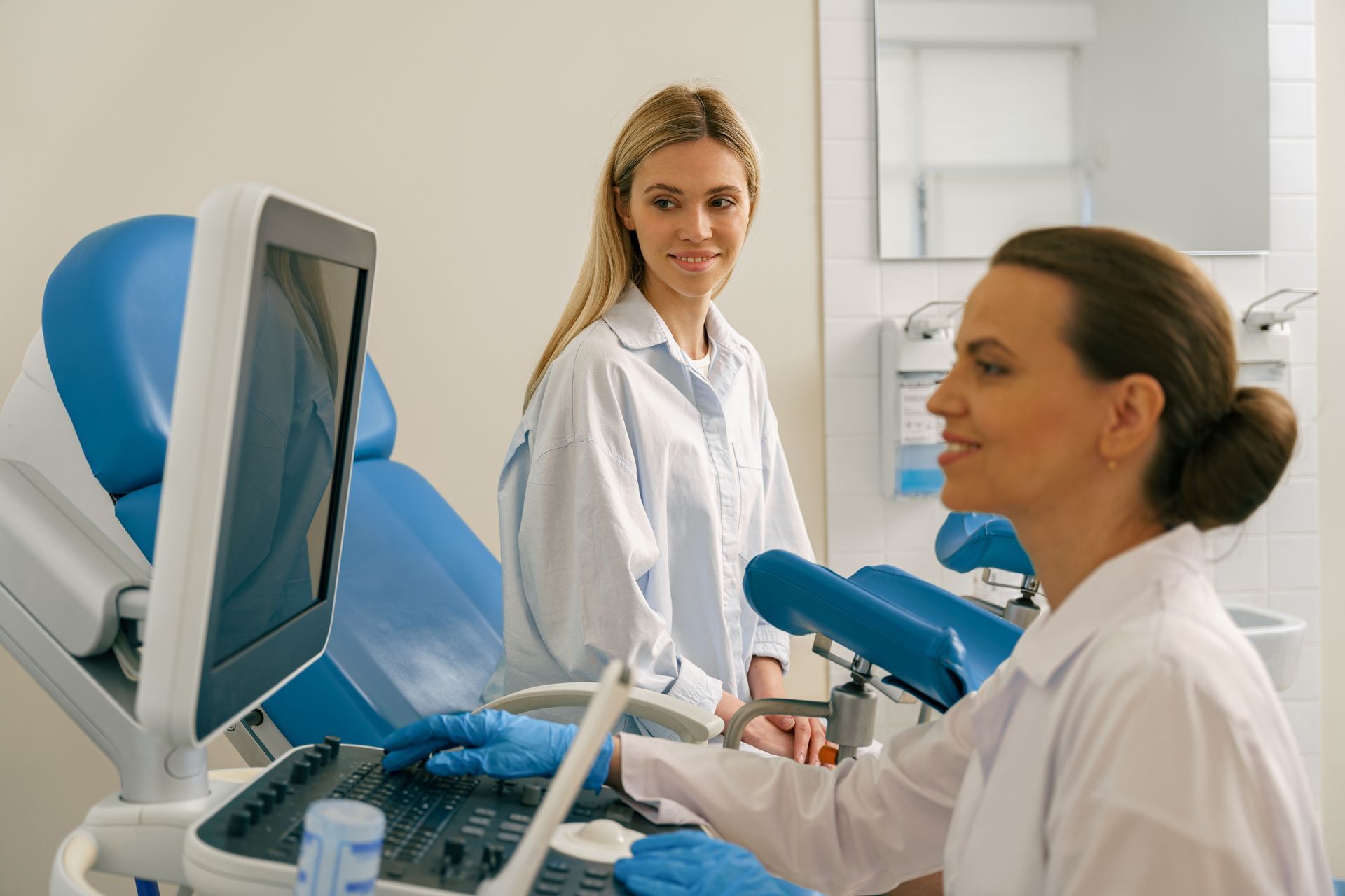 Woman in examination room during ultrasound procedure.