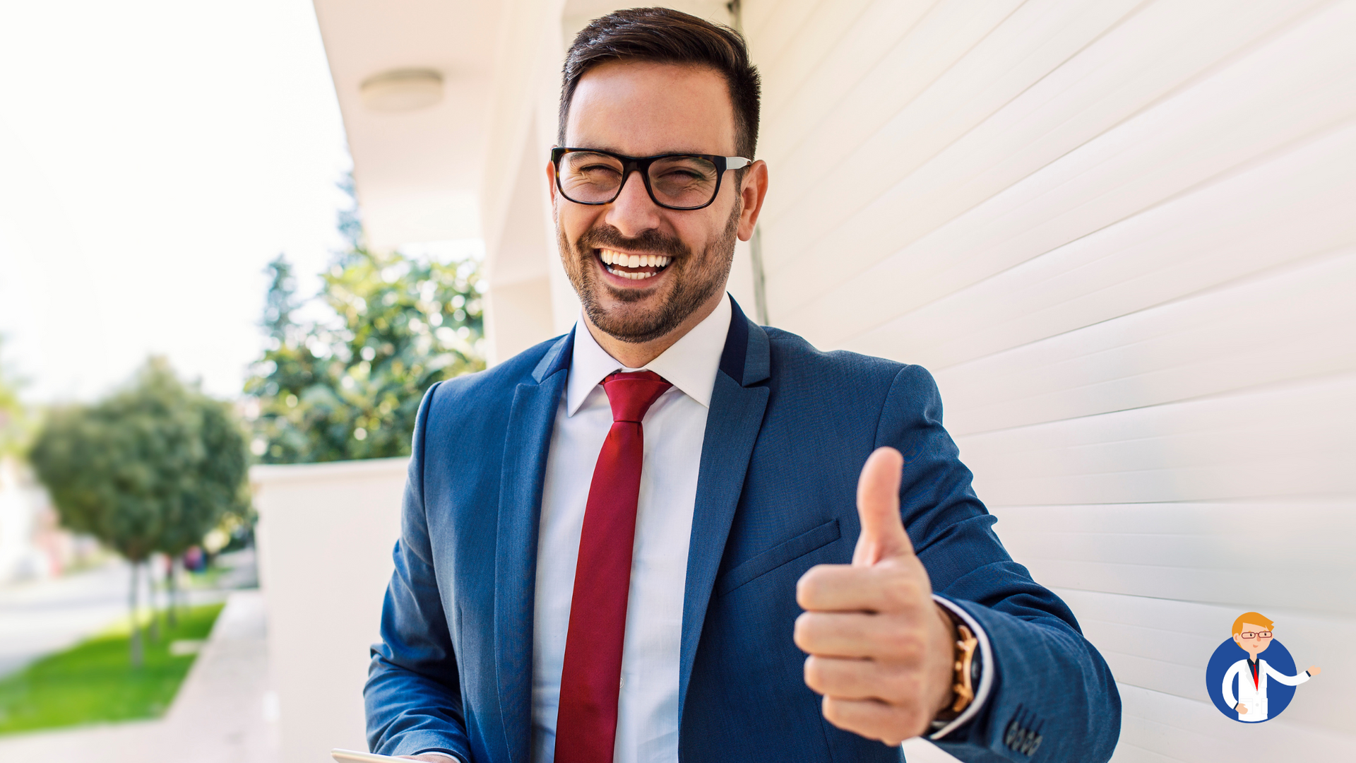 Man in suit giving thumbs up, smiling broadly, outdoors in front of a white building.