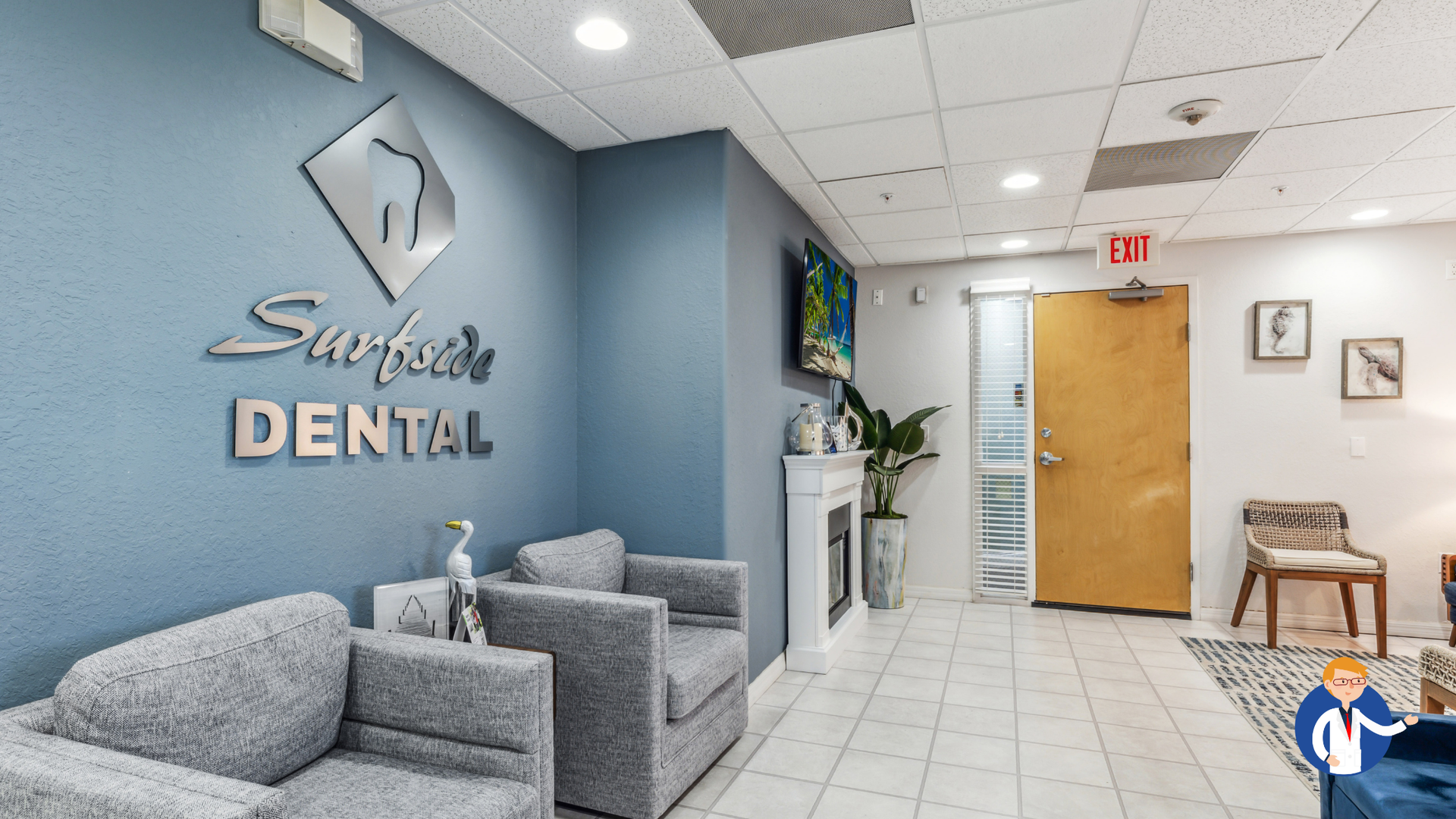 Dental office waiting room with blue wall, gray seating, and logo.