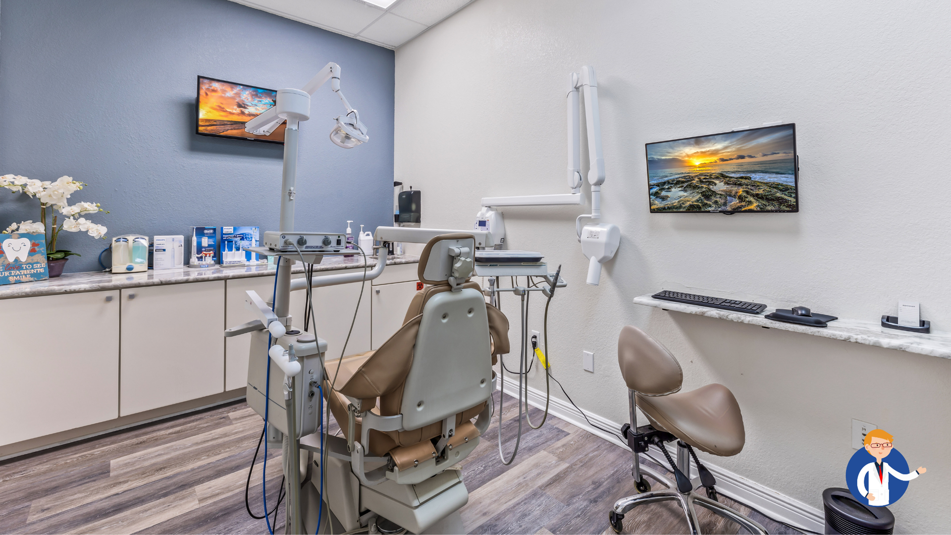 Dental operatory with chair, equipment, and two mounted screens displaying scenic views.
