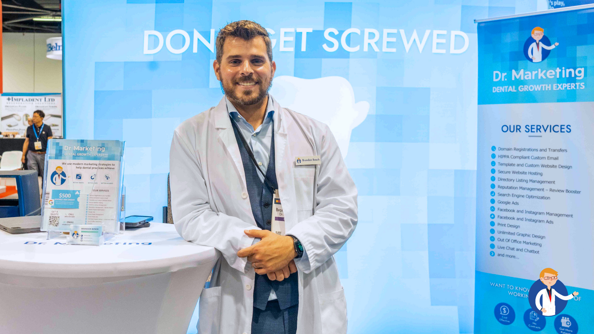 A man in a lab coat is standing in front of a table.