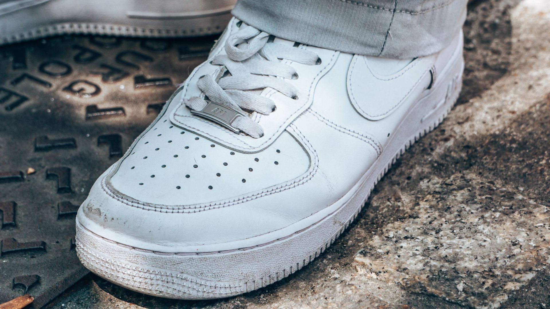 A white sneaker photographed on concrete