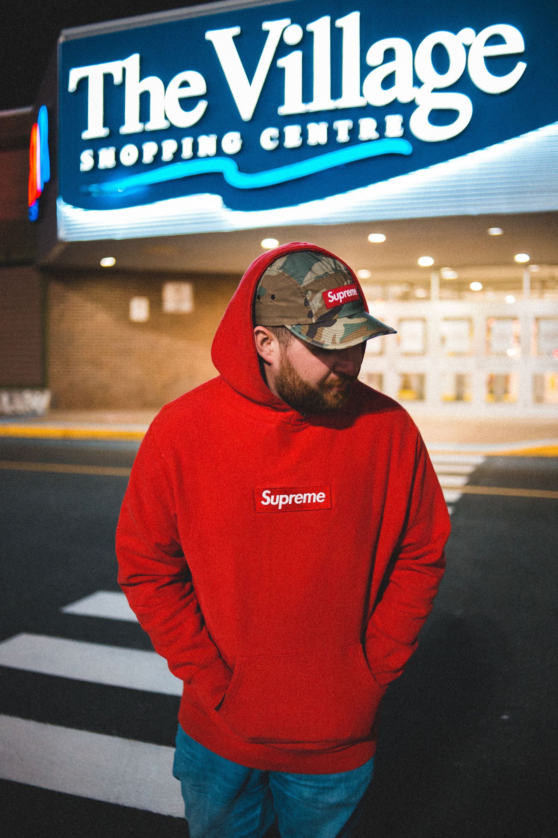 A person wearing a red hooded sweatshirt on the street