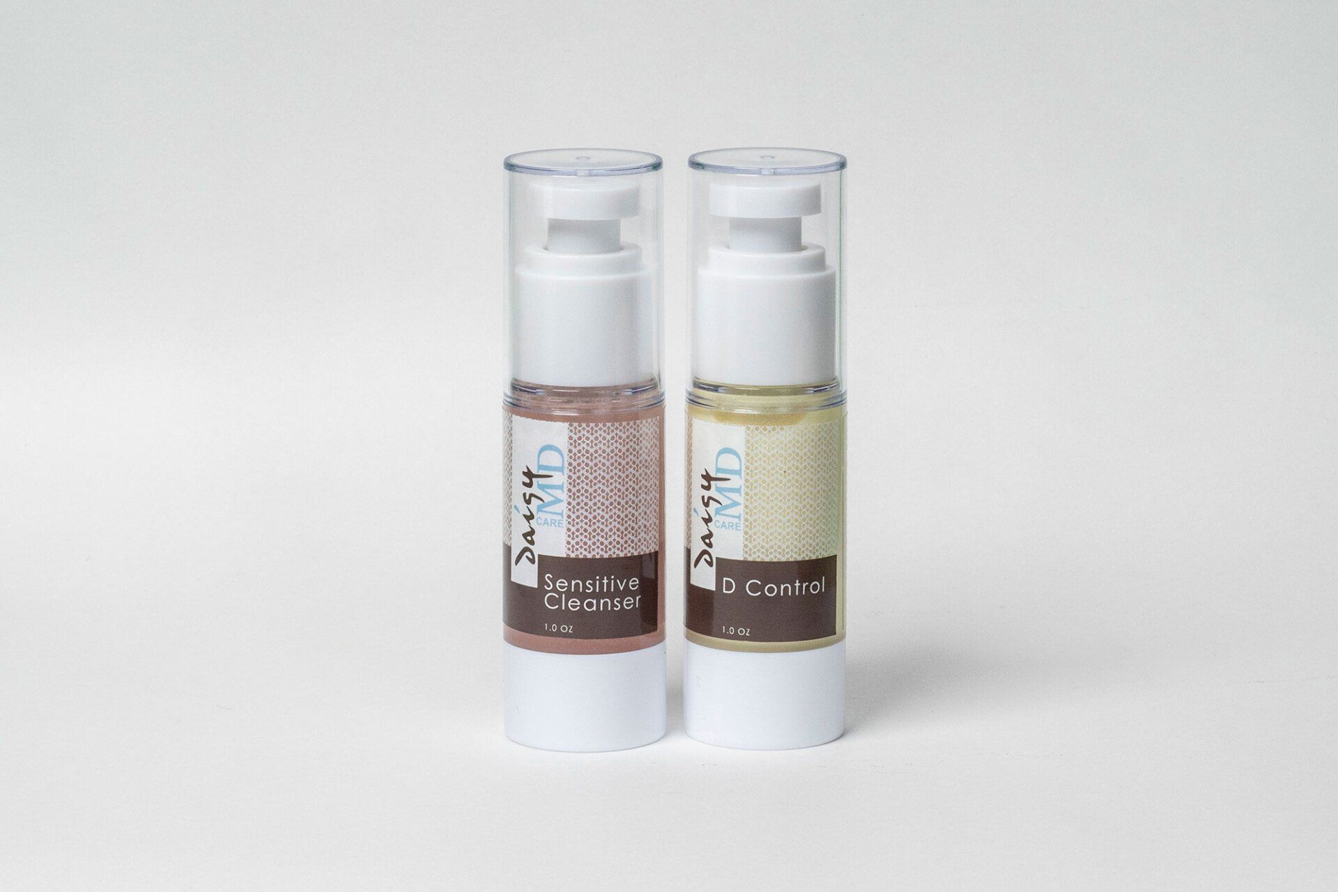 Two skincare product bottles on a white background. One is pink, the other yellow, with white pump tops.