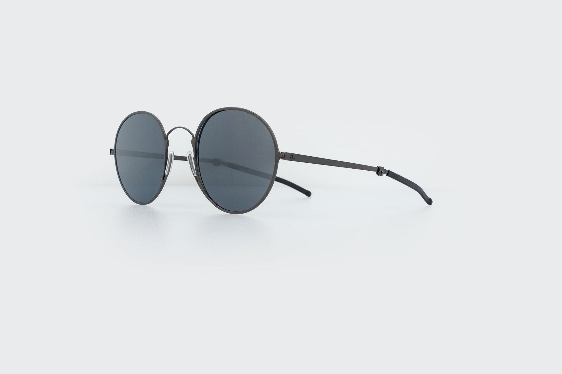 Round, black sunglasses on a white background.
