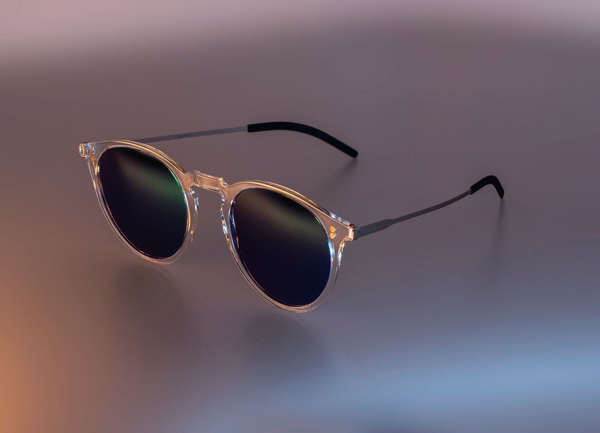 Sunglasses with clear frames and dark lenses on a reflective surface.