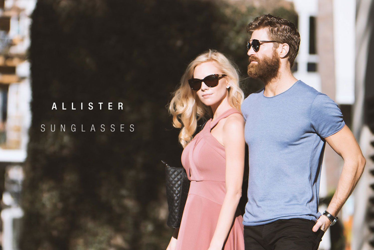 Woman and man in sunglasses walking outside on a sunny day.