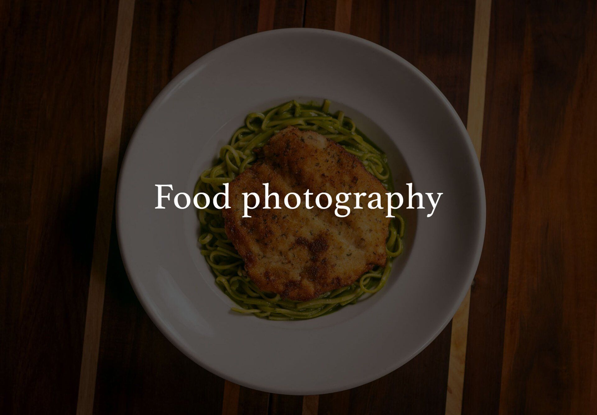 A plate of pasta with chicken, overhead view on a wooden table.