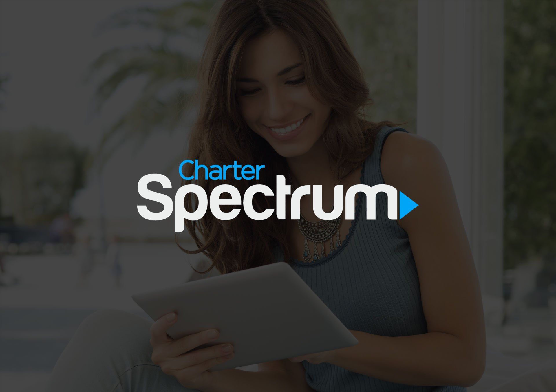 Woman smiling, using a tablet outdoors, Charter Spectrum logo visible.