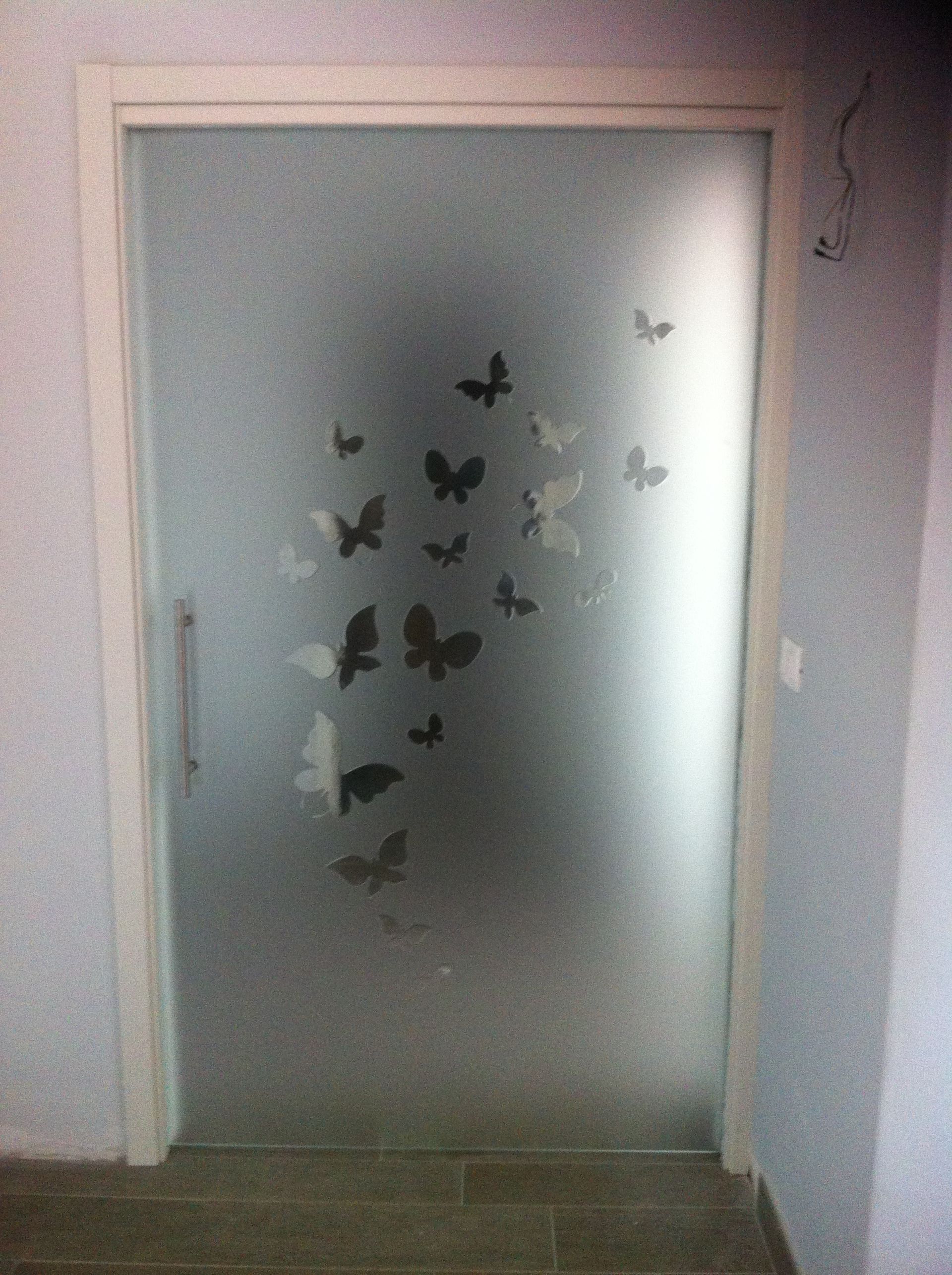 Porta in vetro smerigliato con sagome di farfalle.
