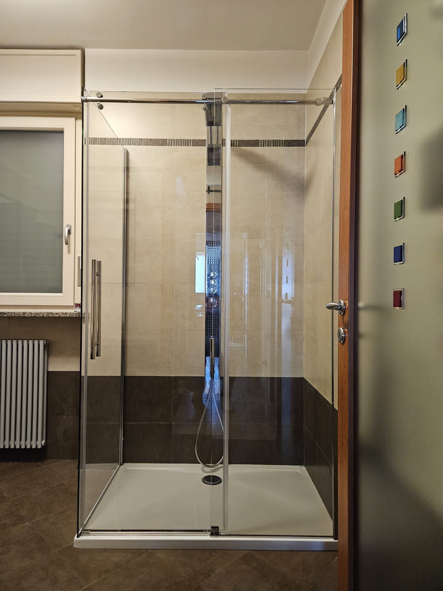 Un box doccia in vetro con porta scorrevole in un bagno.