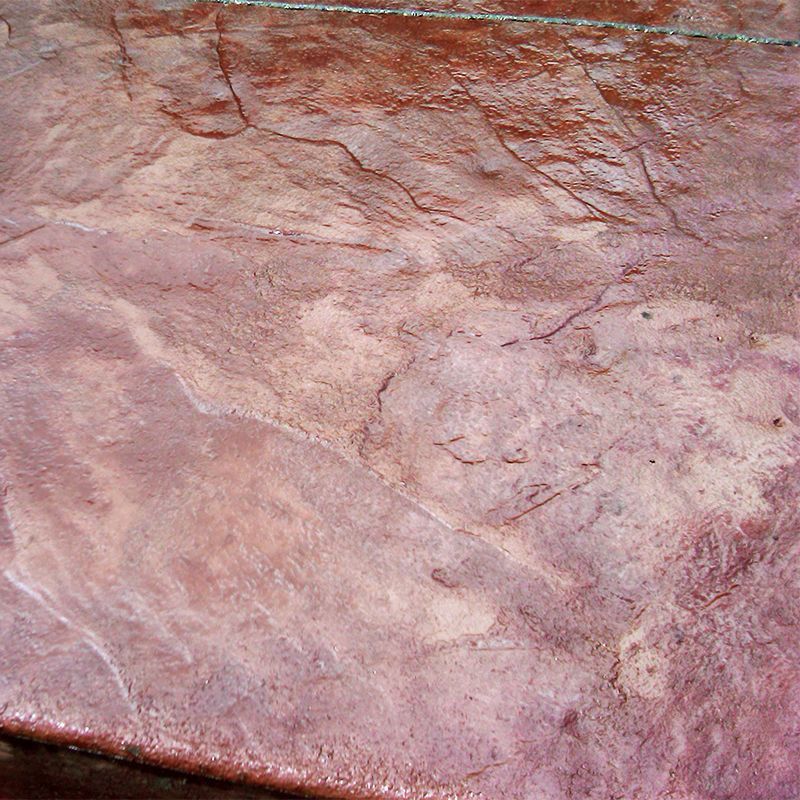 Pinkish textured stone or marble surface with veined patterns