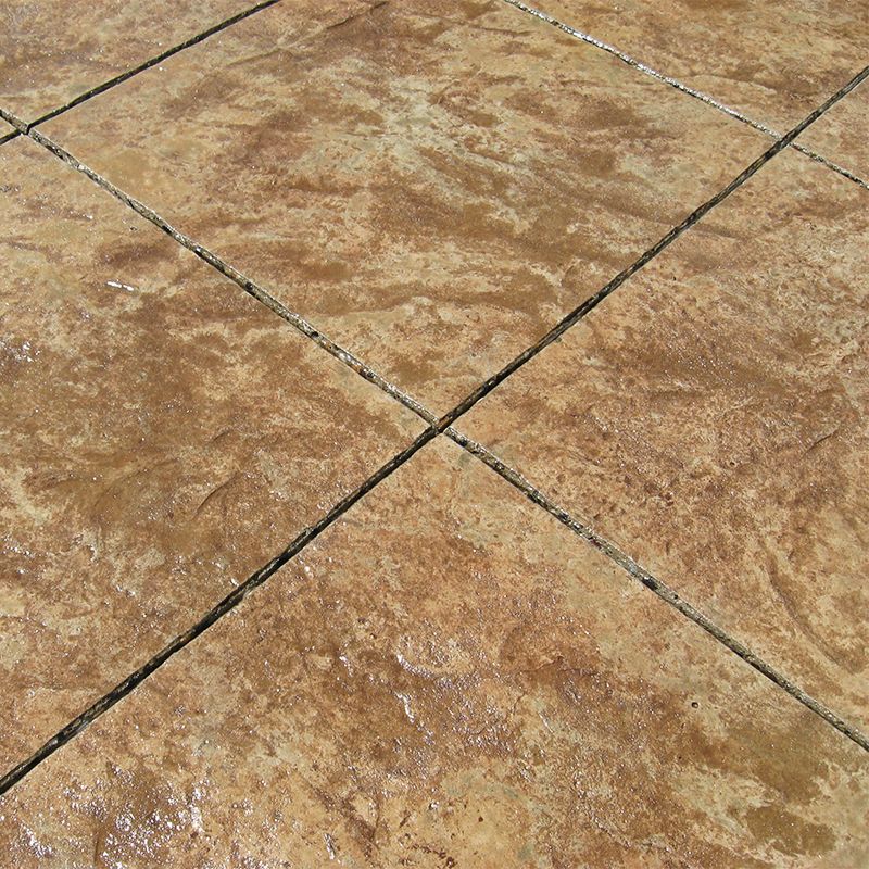 Close-up of tan textured stone tiles with dark grout lines crossing diagonally