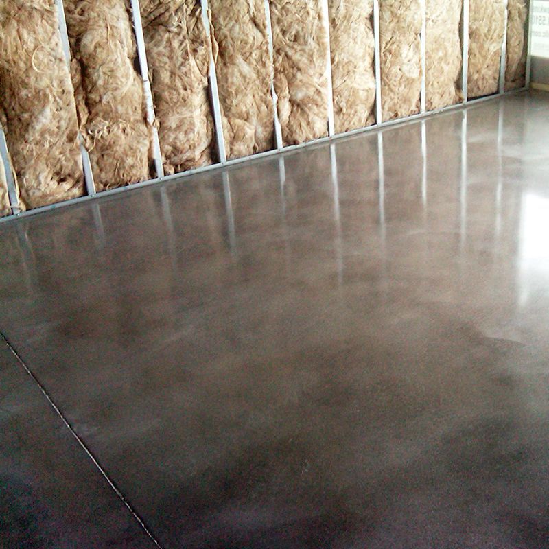Concrete floor inside a framed wall with exposed insulation and metal studs