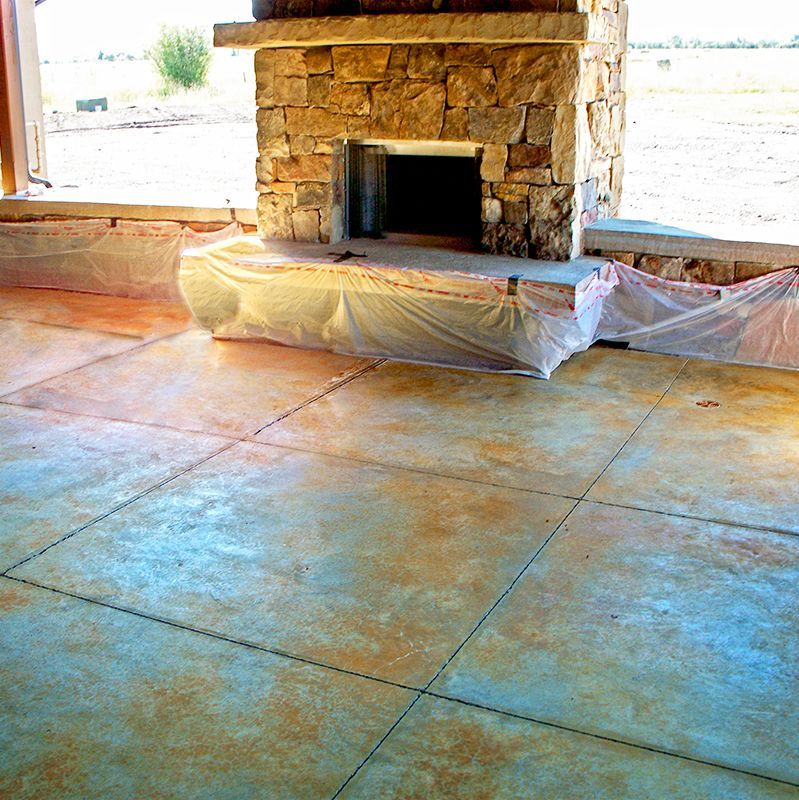Stone fireplace with a covered base in a room under construction, surrounded by tiled floor and open walls