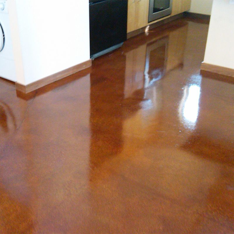 Shiny brown hardwood floor in a kitchen, reflecting light near white cabinets and an oven