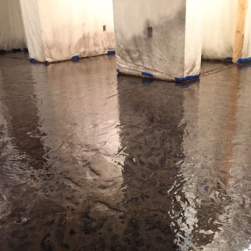Flooded indoor floor reflecting white pillars and walls