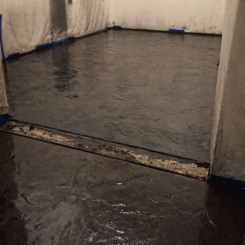 Indoor flooded room with standing water and wet floor barriers along the walls